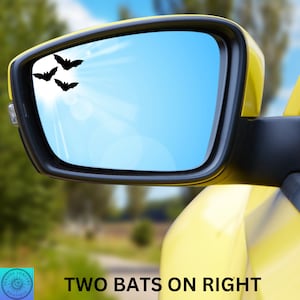 May include: A yellow car with a rearview mirror. The mirror has three black bat decals on the glass. The text "TWO BATS ON RIGHT" is visible below the car.