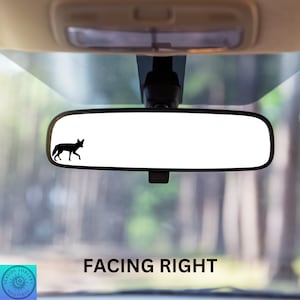 May include: A black silhouette of a fox facing right is visible in the rearview mirror of a car. The text "FACING RIGHT" is printed below the mirror.