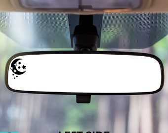 May include: A black and white crescent moon and stars decal on a car's rearview mirror. The decal is on the left side of the mirror. The text "LEFT SIDE" is printed below the mirror.