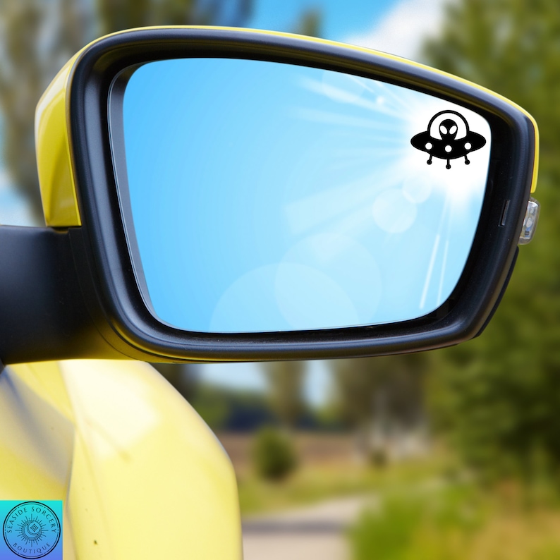 Peut inclure: Une voiture jaune avec un r&eacute;troviseur bleu. Un autocollant de vaisseau spatial extraterrestre noir est sur le miroir.