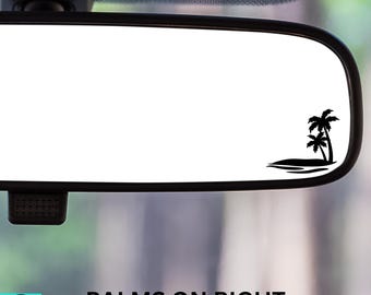 May include: A black silhouette of palm trees on a white background. The image is a rearview mirror sticker that says "PALMS ON RIGHT".