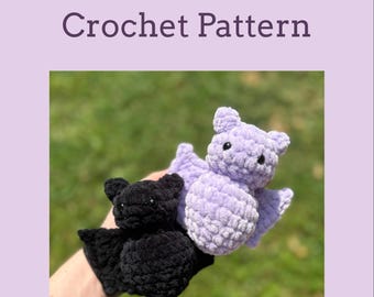 May include: Two crocheted bats, one black and one lavender, are displayed against a blurred green background. The bats have large wings and small ears. The text "Mini Bat Crochet Pattern" is at the top of the image.