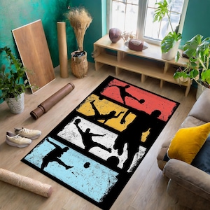 Pode incluir: Um tapete preto e branco com um design retro que apresenta silhuetas de jogadores de futebol em v&aacute;rias poses. O tapete tem um visual desgastado e vintage com um fundo colorido de vermelho, amarelo, azul e branco.