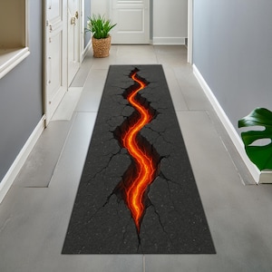 May include: A long, rectangular rug with a 3D graphic of a cracked surface. The crack is filled with a vibrant orange and red lava-like design. The rug is placed in a hallway with white doors and gray walls.
