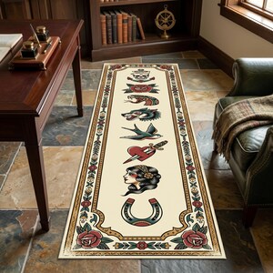 May include: A long rectangular runner rug with a cream background featuring a series of traditional tattoo-style illustrations including a skull, rose, snake, wolf, swallow, heart with dagger, woman's profile, and horseshoe, framed by a floral border.