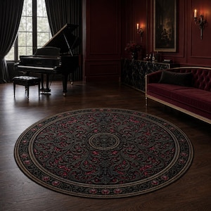 Puede incluir: Una alfombra circular grande con un fondo gris oscuro y negro que presenta intrincados patrones simétricos de hojas de acanto en tonos rojo intenso, oro apagado y gris, rematada con un borde circular decorativo.