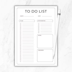 May include: A white To Do List notepad with the words "TO DO LIST" at the top. The notepad has sections for month, date, to-do items, top priorities, notes, and reminders. A white stylus pen rests on the right side.