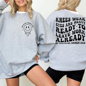 May include: Light gray sweatshirt with black text and a smiley face graphic. The front of the sweatshirt says "WHATEVER EMINEM SAID" with a melting smiley face. The back says "KNEES WEAK EYES ARE HEAVY READY TO LEAVE WORK ALREADY OR WHATEVER EMINEM SAID."