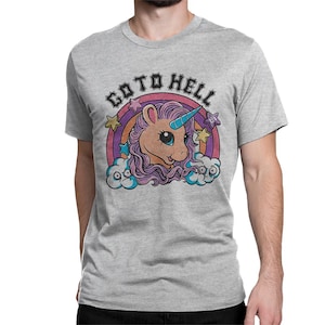 May include: A light gray t-shirt featuring a cartoon unicorn with a blue horn, purple mane, and a rainbow background. The text "GO TO HELL" is above the unicorn in a distressed font.