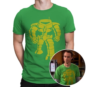 May include: A green t-shirt with a yellow graphic of a robot. The robot has a lightning bolt on its chest. The t-shirt is a popular design from the TV show The Big Bang Theory.