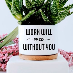 May include: White ceramic planter with a succulent plant. The planter has black text that reads "Work will succ without you".