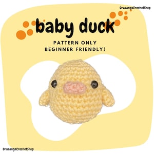 Könnte beinhalten: Gehäkelte Babyente mit gelbem Körper, kleinen Flügeln und einem rosa Schnabel. Der Text "baby duck" steht über der Ente, darunter "PATTERN ONLY BEGINNER FRIENDLY!". Der Hintergrund ist hellgelb mit orangefarbenen Kreisen.