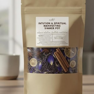 May include: A kraft paper bag labeled "Intuition & Spiritual Manifesting Simmer Pot." The bag's contents are visible, including dried blue flowers, star anise, cinnamon sticks, and dried citrus slices. The text on the label says "enhance intuition, facilitate meditation."