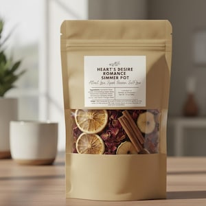 May include: A brown paper bag with a clear window displaying a potpourri mix. The mix includes dried rose petals, orange slices, and cinnamon sticks. The label reads "Heart's Desire Romance Simmer Pot."