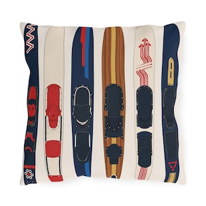 May include: Cushion with a design of vintage water skis in a variety of colours. The skis have red, blue, and brown details, with black bindings. The background is cream with vertical stripes. A retro design for home decor.