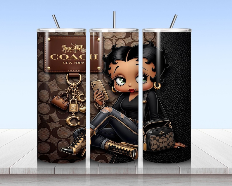 May include: A cylindrical tumbler with a straw featuring a brown monogram pattern, a Coach New York logo patch, and a cartoon character with black hair wearing a black top and ripped jeans, holding a phone and a small handbag with gold accents.