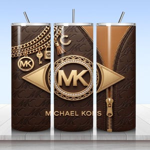 May include: A cylindrical tumbler with a brown leather-textured surface featuring a repeating MK logo pattern. The design includes gold-toned chain graphics, a central circular MK emblem, a vertical zipper detail, and the text MICHAEL KORS.