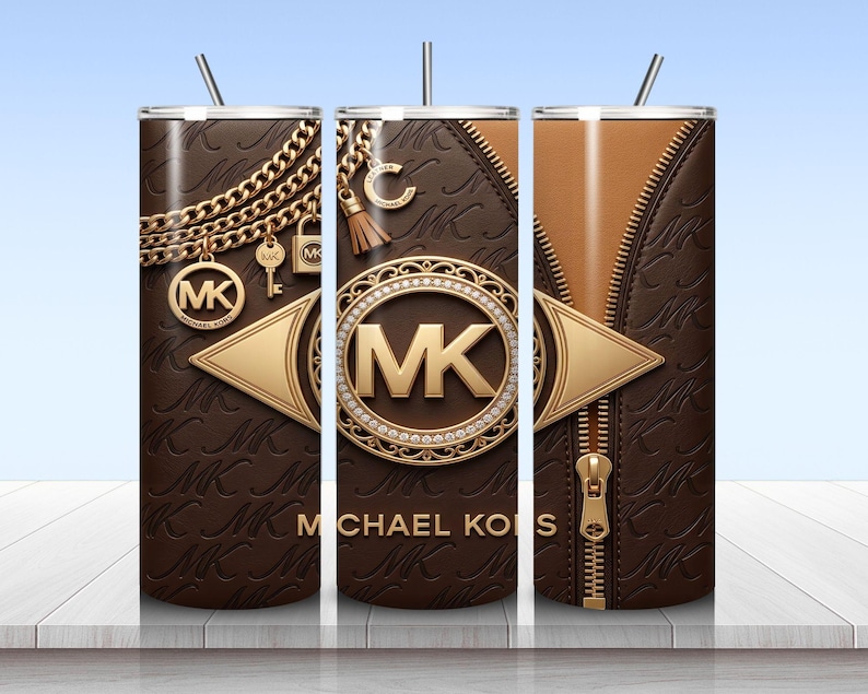 May include: A cylindrical tumbler with a brown leather-textured surface featuring a repeating MK logo pattern. The design includes gold-toned chain graphics, a central circular MK emblem, a vertical zipper detail, and the text MICHAEL KORS.