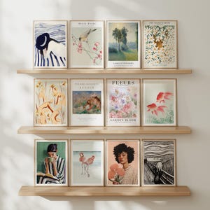 以下が含まれることがあります： 木製の棚に飾られた、額装されたアートプリントのコレクション。プリントは、花柄、風景、肖像画など、さまざまな芸術的スタイルを特徴としています。カラーパレットには、青、緑、ピンク、アースカラーが含まれています。一部のプリントにはテキストがあります。