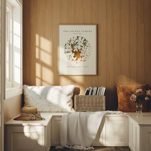 May include: A white poster with a floral illustration and the text "THE SECRET GARDEN" and "You've got a heart of gold." The poster is hanging on a wood wall in a room with a window, a bench, and pillows.