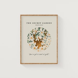 May include: A beige poster with a brown wooden frame features a deer with antlers surrounded by white Shasta daisies. The text "THE SECRET GARDEN" and "SHASTA DAISY" is at the top of the poster. The text "You've got a heart of gold." is at the bottom of the poster.