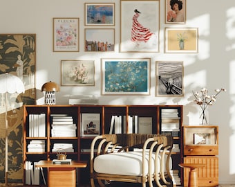 May include: A living room interior with a white armchair, a wooden bookshelf filled with books, and a wall decorated with framed artwork. The artwork includes a floral print, a landscape, a portrait, and an abstract painting. The room is decorated in a mid-century modern style.