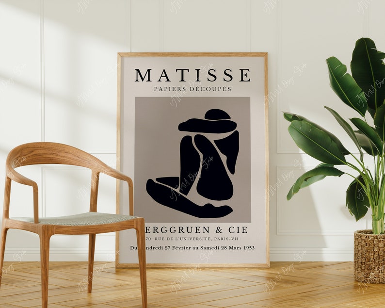 May include: A black and white poster with the text "MATISSE PAPIERS D&Eacute;COUPES" and a black abstract figure on a light brown background. The poster also includes the text "ERGGRUEN & CIE 70, RUE DE L'UNIVERSITE, PARIS-VII Du ndredi 27 F&eacute;vrier au Samedi 28 Mars 1953".