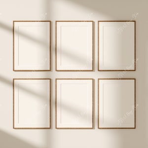 Puede incluir: Seis marcos de fotos vacíos con marcos de madera marrón están dispuestos en dos filas de tres en una pared beige claro. Los marcos son todos del mismo tamaño y forma, y están espaciados uniformemente. La pared está iluminada por luz natural, proyectando sombras de los marcos.