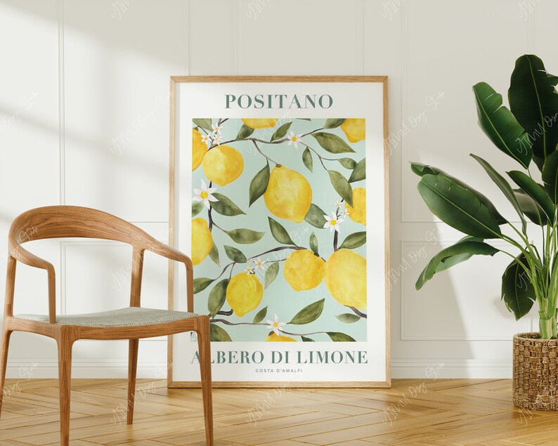 May include: A poster with a watercolor illustration of a lemon tree with lemons and white flowers. The poster has the text "Positano" and "Albero di Limone Costa d'Amalfi" in a teal green font.