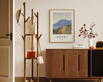 May include: A wooden coat rack with three shelves and a hat rack. The rack is decorated with a hat, a purse, and a handbag. The rack is in front of a brown wooden dresser with a painting of a landscape by Monet hanging above it.