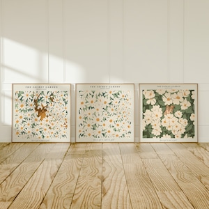 Puede incluir: Tres impresiones enmarcadas con un patrón floral blanco y follaje verde. Las impresiones tienen el texto "The Secret Garden" y "You've got a secret of gold".