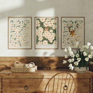 May include: Three framed prints with a white background and illustrations of white flowers. The text on the prints reads "The Secret Garden" and includes quotes from the book.