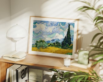 May include: A framed print of a painting depicting a landscape with a blue sky, white clouds, and a tall, dark green cypress tree in the foreground. The painting is in a wooden frame and is hanging on a wall.