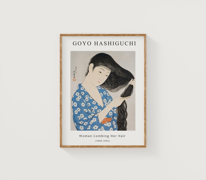 May include: A framed print of a woodblock print by artist Goyo Hashiguchi. The print depicts a woman in a blue and white patterned kimono combing her long black hair. The title of the print is "Woman Combing Her Hair (1900-1945)".