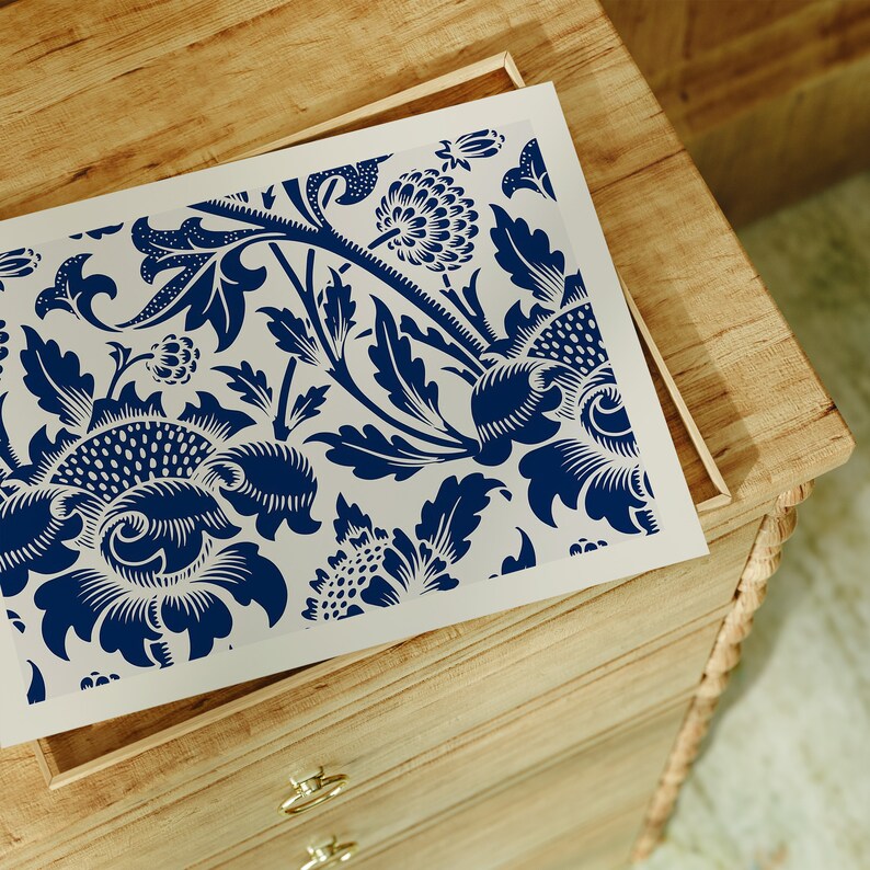 May include: A wooden dresser with drawers features a decorative blue and white floral design on the top drawer. The design is reminiscent of traditional wallpaper.