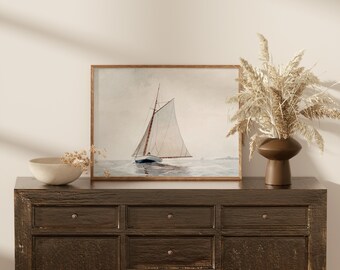 May include: A framed watercolor painting of a sailboat on the water. The sailboat has a white sail and a brown hull. The painting is set against a light blue background. The frame is a simple, brown wood frame.