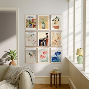 May include: A gallery wall with nine framed prints. The prints feature abstract art, floral designs, and Japanese-inspired artwork. The prints are arranged in a grid pattern on a white wall.