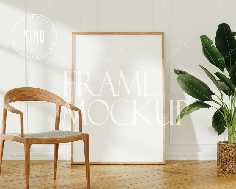 May include: A wooden chair with a light gray cushion sits in front of a white wall with a large, empty picture frame. A potted green plant is on the right side of the image.