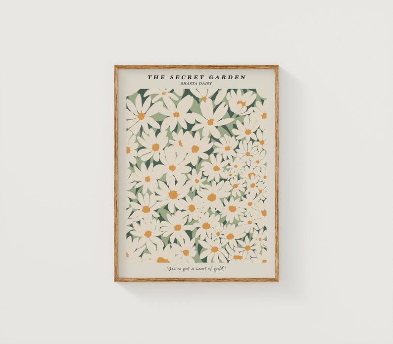 May include: A framed print with a white background featuring a floral pattern of white Shasta daisies with yellow centers on a green background. The text "THE SECRET GARDEN" and "SHASTA DAISY" is at the top of the print. The text "You've got a heart of gold." is at the bottom of the print.