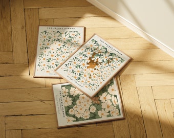 May include: Three framed prints with a floral design and the text "The Secret Garden" on each. The prints feature a white daisy pattern on a green background. The text "You've got a land of gold" is on one of the prints.