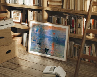 May include: A framed painting of a seascape with a red sun setting over the water. The painting is in a wooden frame and is hanging on a bookshelf.