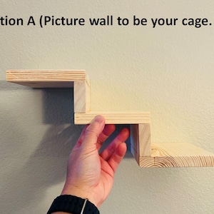 May include: A wooden shelf unit with three steps, mounted on a wall. The shelf unit is made of natural wood and has a simple design.