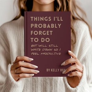 May include: A burgundy notebook with the text "THINGS I'LL PROBABLY FORGET TO DO BUT WILL STILL WRITE DOWN SO I FEEL PRODUCTIVE" in gold lettering. The notebook is titled "BY KELLY ROAN".