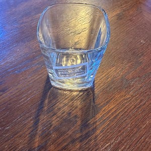 K&ouml;nnte beinhalten: Ein klares Glas mit quadratischem Boden und einem John Walker & Sons Red Label Scotch Whisky Logo auf der Unterseite.