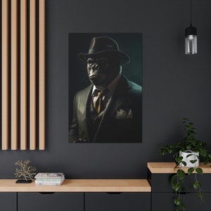 May include: A black and white portrait of a gorilla wearing a dark brown fedora and a dark suit with a gold tie. The gorilla has a serious expression on its face.