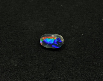 May include: A small, oval-shaped opal gemstone with a rainbow of colors, including blue, green, red, and orange, visible inside.