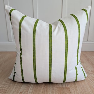 May include: White pillow with green stripes. The pillow is made of a soft, textured fabric.