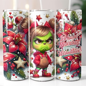 May include: A white tumbler with a Christmas-themed design featuring a green, cartoon monster with red hair and a red and black outfit. The monster is surrounded by red poinsettia flowers, green holly, and gold stars. The text on the tumbler reads "Ich hasse Menschen! Ganz besonders an Weihnachten!"