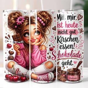 May include: A cylindrical tumbler featuring a cartoon illustration of a person with brown hair in buns, wearing a pink sweater and white jeans, holding a chocolate bar. The design includes cherries, chocolate pieces, and the German text: "Mir ist heute nicht gut Kirschen essen! Schokolade geht."