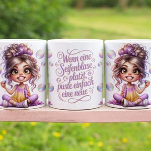 May include: Three white ceramic mugs with a cartoon illustration of a girl blowing bubbles. The girl has purple hair and is wearing a yellow and purple outfit. One mug has German text.